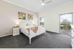 a bedroom with a white bed and a window at Riverbend Ranch Tamborine in Tamborine +33 photos