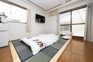 Cama grande en habitación con ventanas en 匯金芝浦ビル, en Tokio