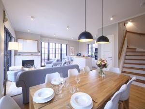 ein Esszimmer und ein Wohnzimmer mit Tisch und Stühlen in der Unterkunft Reetland am Meer - LuxusPlus Reetdachvilla mit 4 Schlafzimmern, Sauna und Kamin G13 in Dranske