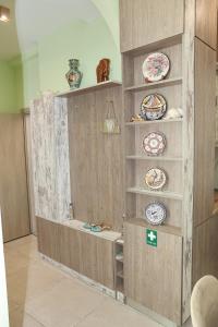 a wooden wall with plates and dishes on it at Cleos House in Trýgonas