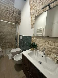 a bathroom with a white sink and a toilet at Antica Roma 122 in Sammichele di Bari