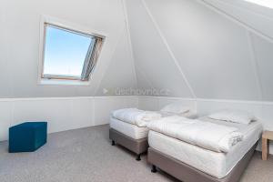 two beds in a room with a window at Camping 2000 - Vakantiewoning M in Osečná