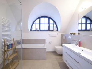 ein Badezimmer mit Badewanne, Toilette und Waschbecken in der Unterkunft Reetland am Meer - LuxusPlus Reetdachvilla mit 4 Schlafzimmern, Sauna und Kamin G14 in Dranske + 11 Fotos