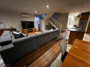 a living room with a couch and a television at The Ryrie Loft in Geelong +4 photos