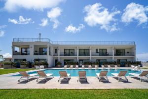 a resort with chairs and a swimming pool at Ella Suites Apartments in Terrasini