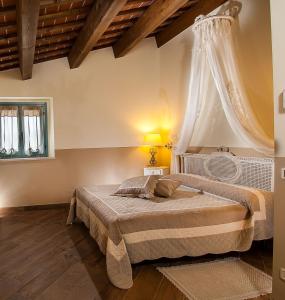 ein Schlafzimmer mit einem Bett mit weißem Baldachin in der Unterkunft Casa Monsignore in San Giovanni in Marignano
