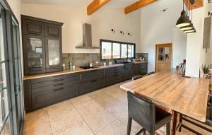 a kitchen with a wooden table and a large kitchen at Maison Avec Piscine Privée in Châteauneuf-du-Pape