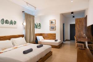 a hotel room with two beds and a piano at Chiang Mai Mansion 2 in Chiang Mai