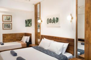 a hotel room with two beds and a mirror at Chiang Mai Mansion 2 in Chiang Mai