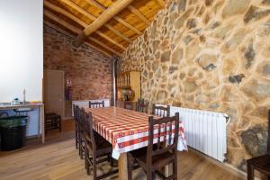 a dining room with a table and a stone wall at Casa Tunino in Monforte de Lemos