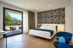 a hotel room with a bed and a balcony at Ella Suites Apartments in Terrasini +109 photos