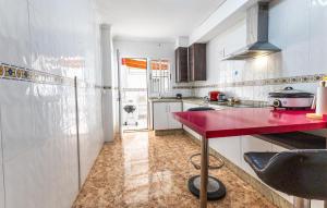 a kitchen with a red counter in a room at 3 Bedroom Amazing Home In Los Alcazares in Los Alcázares