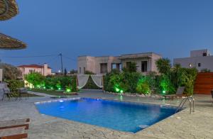 een zwembad voor een huis met verlichting bij Villa Di Georgia in Afantou