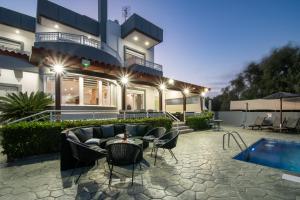 een huis met een patio en een zwembad bij Villa Di Georgia in Afantou