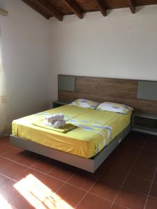 a bedroom with a bed with a yellow bedspread at Andronikis House in Sykia Chalkidikis