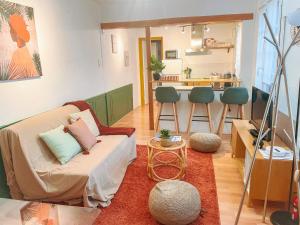 a living room with a couch and a kitchen at Échappée Urbaine Rouennaise - Hypercentre - Gare Rive Gauche in Rouen +20 photos