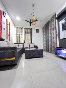 a living room with a couch and a tv at Night View Apartment in Ghaziabad +38 photos