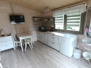 a kitchen with white cabinets and a table and a sink at Chata Studenec in Studenec
