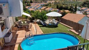 a swimming pool in a yard with a table and chairs at Villa Alfaguara-Holiday Home Granada & Sierra Nevada in Granada