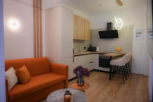 a living room with a couch and a kitchen at White Luxury Suite in Katerini