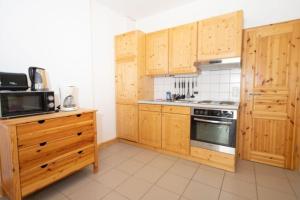 a kitchen with wooden cabinets and a stove top oven at Ferienwohnung Forsthaus am Brocken, 35 qm, 1 Wohn-Schlafzimmer F1 in Ilsenburg +6 photos