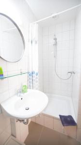 a white bathroom with a sink and a shower at Ferienwohnung Forsthaus am Brocken, 35 qm, 1 Wohn-Schlafzimmer F1 in Ilsenburg