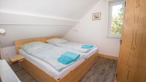 a bedroom with a bed with blue sheets and a window at Ferienwohnung Forsthaus am Brocken, 60 qm, 3 Schlafzimmer F5 in Ilsenburg