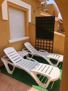 three lounge chairs and a window on a balcony at Paraíso in Cumbre del Sol