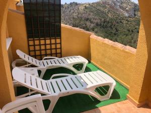 two white lounge chairs on a balcony with a view at Paraíso in Cumbre del Sol