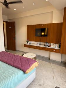 MehekarVedika resort loadging and boarding的一间配有床和平板电视的酒店房间
