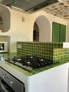 a kitchen with green tile on the counters and a stove at Villa charmante à Villecroze avec piscine privée in Villecroze
