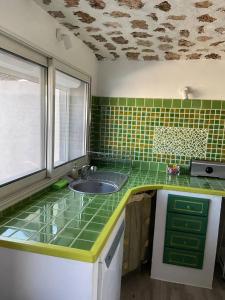 a green tiled kitchen with a sink and a window at Villa charmante à Villecroze avec piscine privée in Villecroze +57 photos