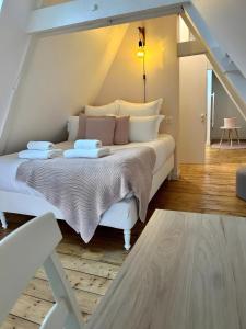a bedroom with a white bed with two dishes on it at La Maison Du Phare in Plérin