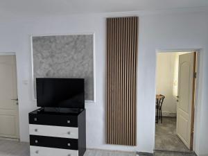 a living room with a television on a dresser at AME Home in Ocna-Mureşului