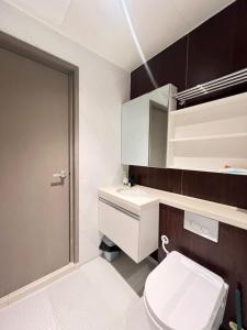 a bathroom with a toilet and a sink and a mirror at Bay Suite Likas by IGVC in Kota Kinabalu