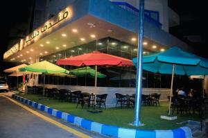 a group of tables and umbrellas in front of a building at Delmar Hotel Matrouh in Marsa Matruh