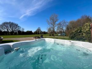 a hot tub in the middle of a yard at Locks Lane Cottage in Geldeston