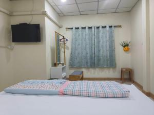 a bedroom with a bed with a tv on the wall at AP House in Sathani Hat Yai