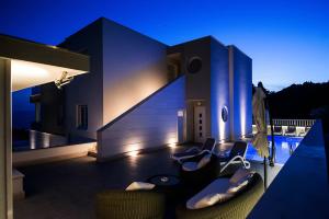 a house with chairs and a swimming pool at night at Lux Apartments in Makarska