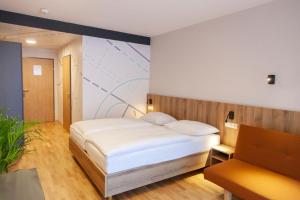 Łóżko lub łóżka w pokoju w obiekcie JUFA Hotel Mariazell