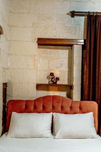 a red couch with two pillows in a bedroom at sermest house in Sanlıurfa +2 photos