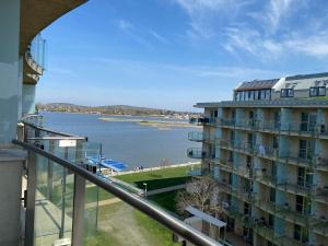 韦伦采VR Spa Apartman的阳台上可欣赏到建筑物和水体的景色