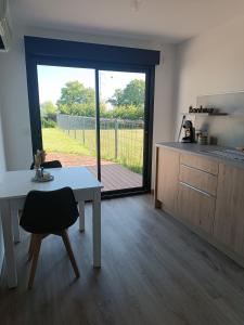 a kitchen and dining room with a table and a window at Maison studio de jardin in Naucelles