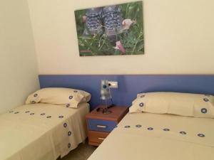 a bedroom with two beds and a picture on the wall at room facing the sea in L'Ampolla
