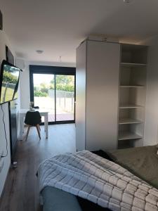 a bedroom with a bed and a sliding glass door at Maison studio de jardin in Naucelles