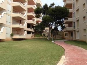 a large apartment building with a green lawn in front of it at room facing the sea in L'Ampolla