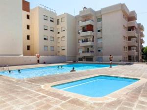 a swimming pool in front of some apartment buildings at room facing the sea in L'Ampolla