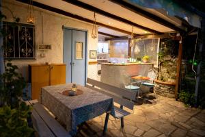 eine Terrasse mit Tisch und eine Küche in einem Haus in der Unterkunft Faros - Drosostalides, Milina in Milína
