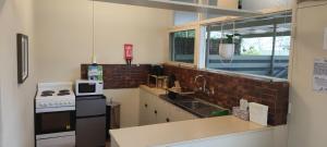 una cocina con fregadero y estufa horno superior en The Grove Getaway 2 min walk to train and shops, en Sturt