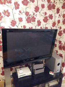 a flat screen tv sitting on top of a table at The Holbein Three bedroom home near tilgate park private parking and garden in Crawley